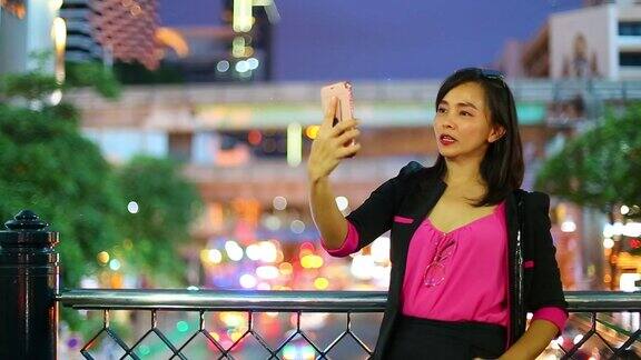 亚洲女商人自拍手机与夜景