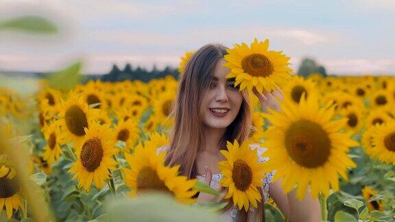 女孩在田野里的黄花中摆姿势向日葵场人像视图