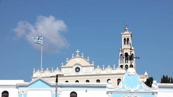 希腊国旗旁边的教堂在蒂诺斯岛