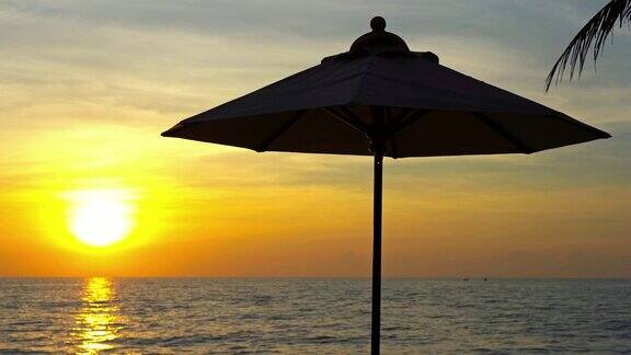 日出时美丽的雨伞和椅子在海滩附近的游泳池周围