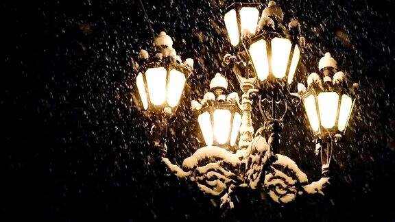 夜冬路灯和飘落的雪花灯在晚上街灯以飘落的雪为背景