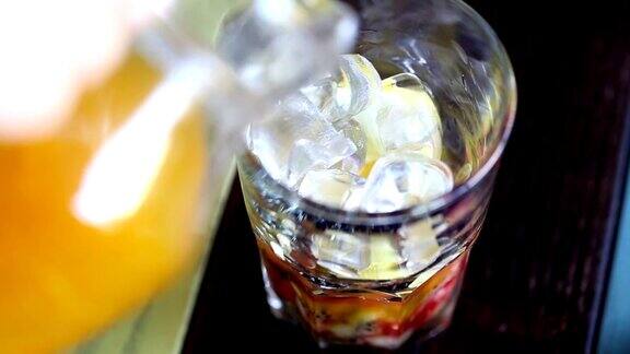将果汁倒入加冰块的玻璃杯中俯视图