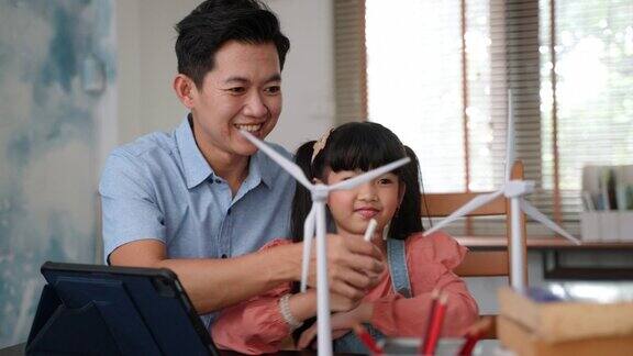 亚洲单亲父亲用风力发电机模型教女儿清洁能源的可持续性