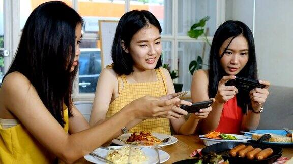 年轻迷人的亚洲姑娘们偷拍照片发到社交媒体上午餐吃的是意大利菜、香肠和沙拉