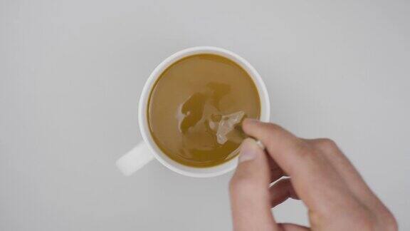 男手杯热咖啡特写俯视图商务和饮料概念顶视图的人用勺子在灰色的木桌上搅拌咖啡关闭了缓慢的运动