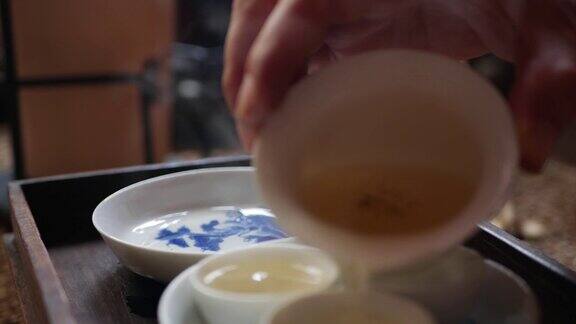 茶师将绿茶倒入盖碗或钟的茶杯中传统的中国功夫或功夫茶道中国传统文化元素特写镜头4k