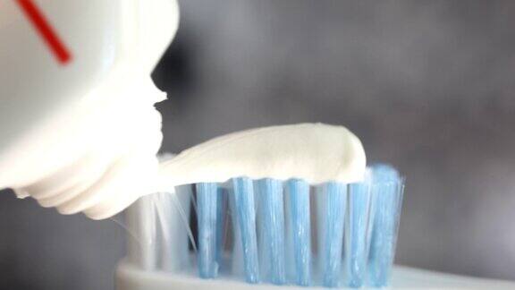 女性将白色牙膏涂在牙刷上