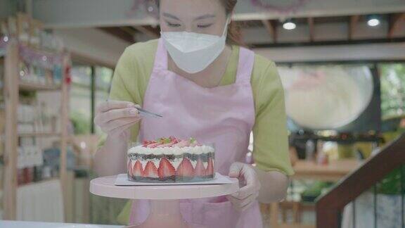 专业厨师正在做蛋糕现代厨房中白色蛋糕顶部草莓的特写