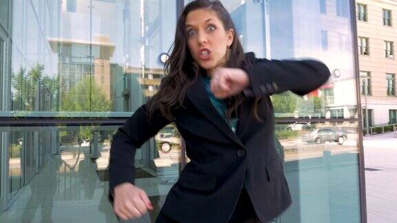 一位女商人在办公楼外疯狂地跳舞庆祝她的成功