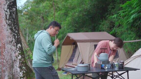 接近亚洲华人中成年夫妇在早上煮水准备咖啡在露营