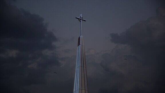 高高的十字架从教堂的屋顶外飞过暴风雨的天空