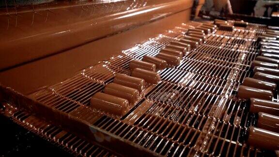在糖果工厂的生产线上糖果被浇上巧克力