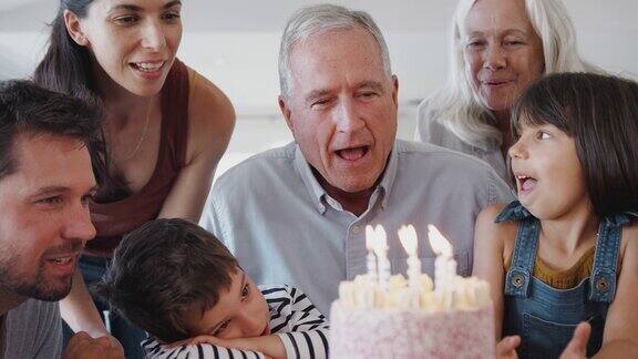 爷爷在家里吹蜡烛多代同堂庆祝生日