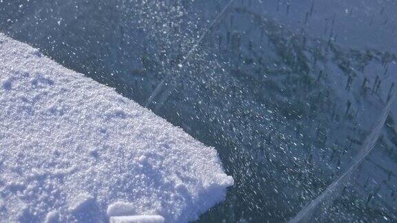 雪在冰面上飞舞雪花在贝加尔湖的冰面上飞舞冰非常美丽有独特的裂缝雪花闪耀着红光在日落时分高对比度