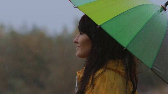 女人站在伞下享受秋雨