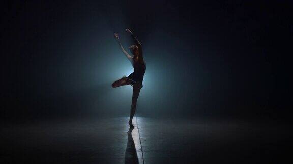 优雅的体操运动员在室内旋转苗条的女人在黑暗的空间跳舞