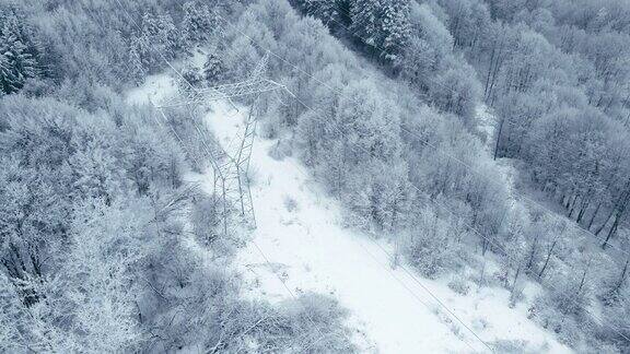 冬季高空鸟瞰图高压线在雪山森林