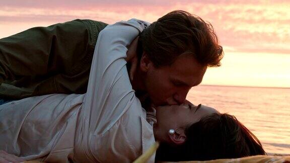一对相爱的夫妇在海边躺着亲吻
