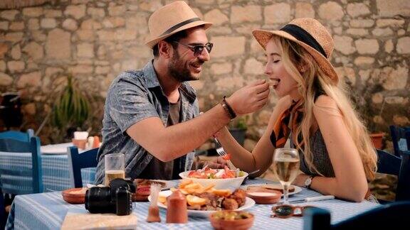 年轻的游客夫妇在传统的希腊酒馆吃午餐