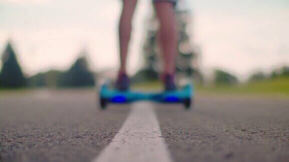 人开始在柏油路上骑着旋转滑板车移动人在自我平衡悬浮滑板上