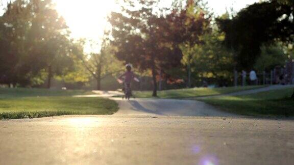小女孩慢慢地骑着自行车去操场