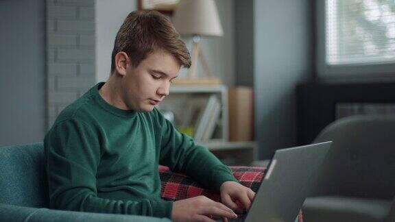 男孩用笔记本电脑做作业