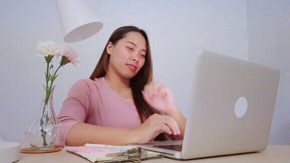 亚洲妇女在家里用笔记本电脑做家庭作业