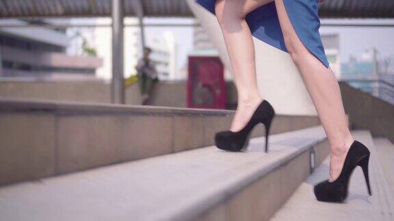 女商人的腿踩在楼梯上踩在城市里