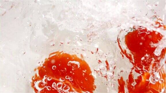 几个红色的西红柿掉进水里白色背景