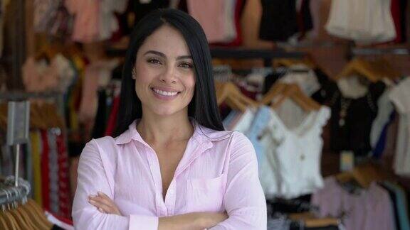 美丽的女企业主服装店面对镜头双臂交叉微笑