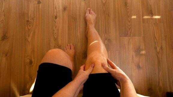 女人坐在床上按摩双膝关节疼痛的观点
