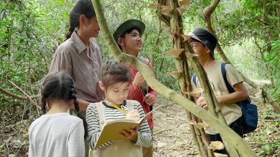 亚洲女性教师正带领学生进行自然之旅从真实的地方、教育理念和冒险中研究自然
