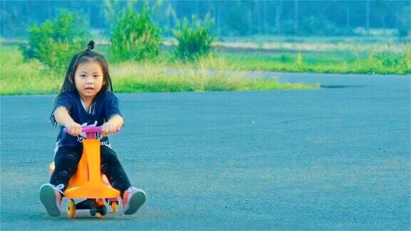 亚洲小女孩在乡下玩秋千车