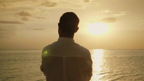 斯坦尼康镜头:孤独的男人期待着海面上的日落后视图浪漫和海上度假4K慢动作视频