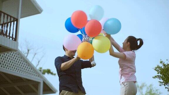 无忧无虑的夫妇在花园房子玩气球慢动作