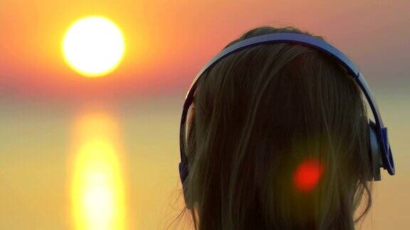欣赏音乐和日落的女人