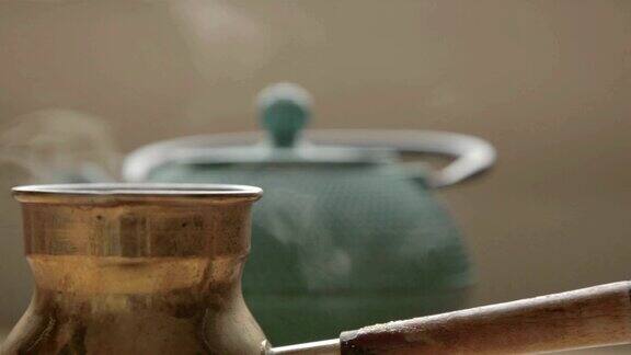 一个传统的带有蒸汽的咖啡壶放在一个带盖子的绿茶柜子前