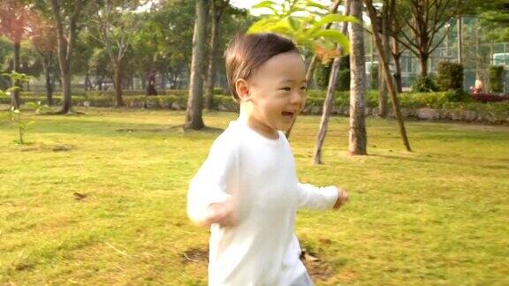 小男孩在花园里奔跑慢镜头