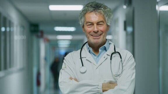 微笑的男医生满意他的工作在一个医院的走廊肖像