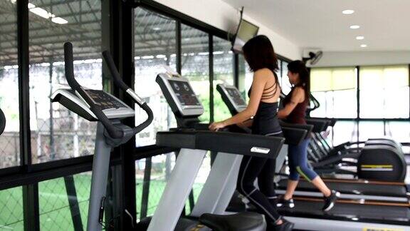 模糊亚洲妇女走在跑步机上健身锻炼