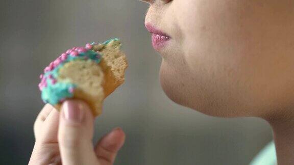 特写视频的胖女人吃甜甜圈的胃口不健康的食物