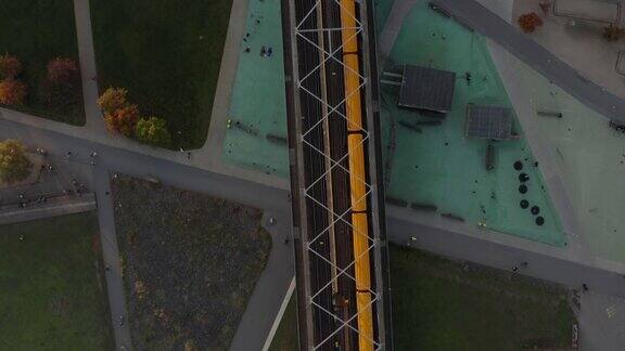 在德国柏林黄色的地铁经过公共公园的桥上空中鸟瞰从上到下的视角