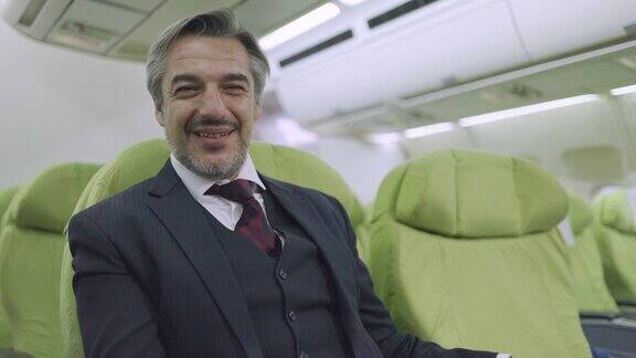 一个成熟的商人坐在飞机上的肖像