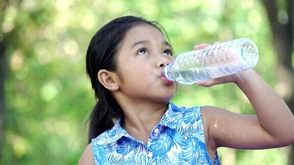 亚洲女孩在公园里喝水