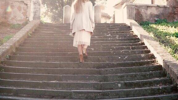 年轻时尚的女子走在城市老街上爬着楼梯在欧洲度假的女孩