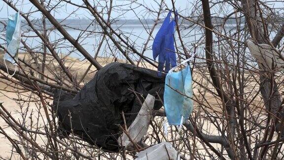 特写镜头树枝上的口罩和塑料袋在风中摇摆新冠肺炎正在加剧污染丢弃的口罩和塑料垃圾混杂在城市的公园里
