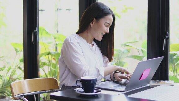 亚洲商业女性使用手机和触摸智能手机进行交流女性使用笔记本电脑在咖啡店工作