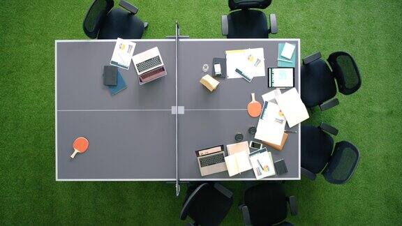 为运动健康和活跃的商务人士提供创意工作空间笔记本电脑和网球桌以上的椅子纸张和电脑在商务会议后在环保办公室的桌子上