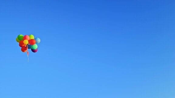一群彩色的气球漂浮在清澈的蓝天上