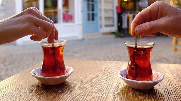 用勺子在一杯土耳其茶中慢动作搅拌糖